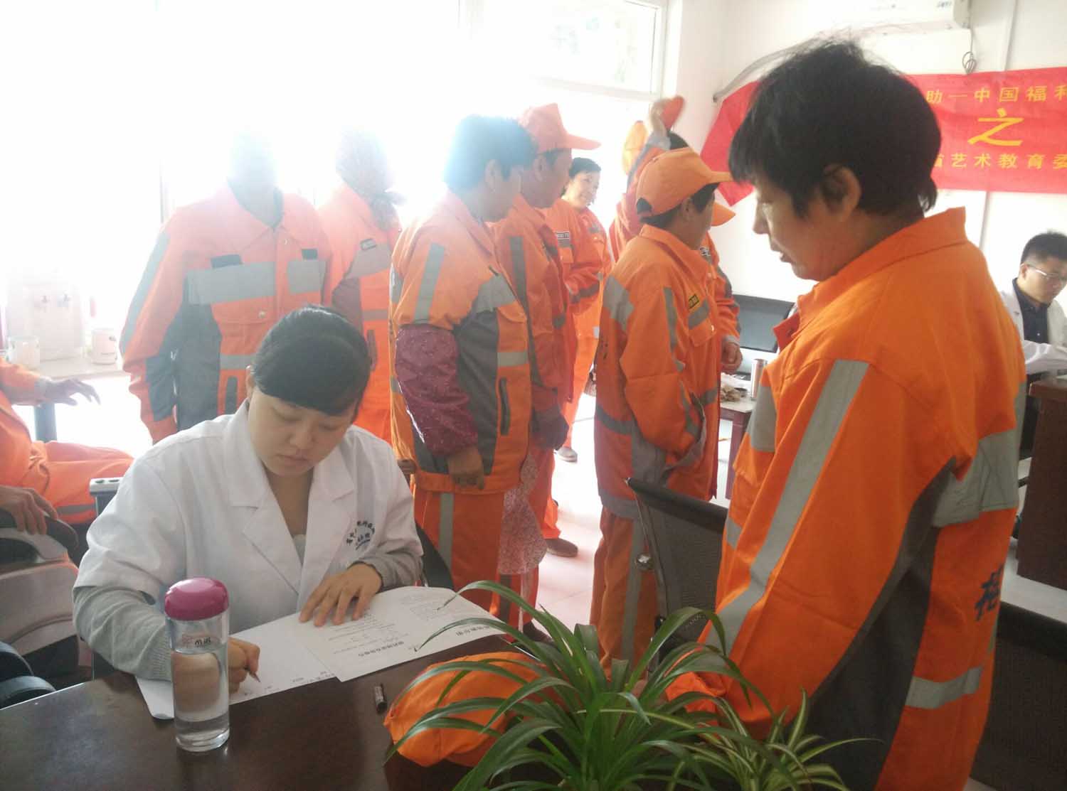 医疗志愿者认真记录环卫工人的身体状况